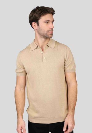 Polo en tricot beige avec un col plat, une patte de boutonnage à trois boutons et des manches courtes. Possède des poignets et un ourlet côtelés.