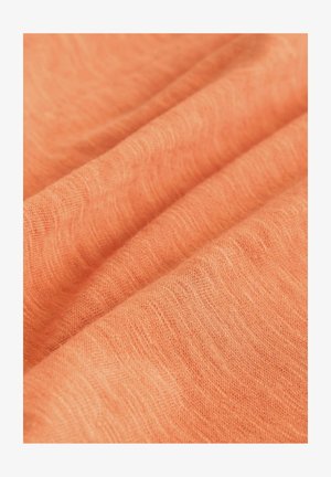 Ľahká, textúrovaná látka v jemnej koralovej farbe, s diskrétnymi tkanými vzormi a jemným padaním, ideálna na odevy.