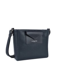 Sac bandoulière en cuir bleu marine avec une finition texturée, comportant une poche à rabat à l'avant et une bandoulière. Logo de la marque visible à l'avant.