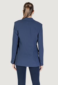 Blazer navy realizzato in tessuto morbido, con un design strutturato, rever a punta e dettagli con bottoni sulle maniche. Vista posteriore.