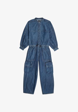 Combinaison en denim avec de longues manches bouffantes, un col rond, une taille cintrée et plusieurs poches cargo. Denim bleu avec des détails de couture visibles.