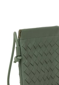 Grøn læder clutch taske med et vævet diamantmønster, flad design og en side rem med en knyttet detalje. Lynlås lukning for oven.