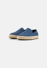 Scarpe blu slip-on in tessuto con suola in juta intrecciata. Texture liscia, punta arrotondata e senza hardware o decorazioni visibili.