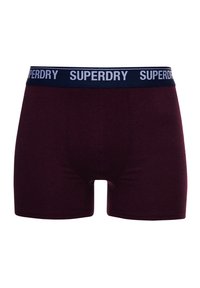 Bordeaux boxer shorts met een marineblauwe elastische tailleband waarop "SUPERDRY" in witte tekst is gedrukt. Gladde stof met een nauwsluitend, aansluitend ontwerp.