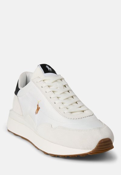 Witte sneaker met een bovenwerk van mesh en suede accenten, voorzien van een zwarte hieltab, witte veters en een bruine rubberen zool. Geborduurd logo detail.