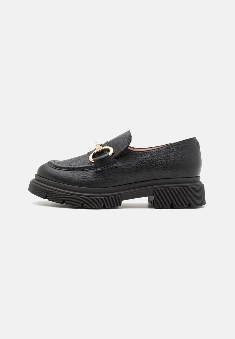 Sorte læder loafers med en bred, struktureret overdel, guldfarvet hardwareaccent og en kraftig gummisål med dybe riller for godt greb.