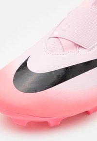 Scarpino da calcio rosa con il logo Nike nero, parte superiore testurizzata e una robusta cinghia sopra per una vestibilità sicura.