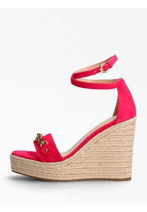 Sandale à talon compensé en suède rose avec une semelle intermédiaire en corde tressée et une bride de cheville, ornée d'accents en métal doré à l'avant.