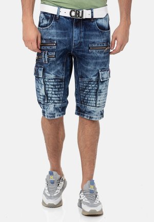 Denim-Cargo-Shorts in einer verblassten blauen Waschung, mit mehreren Zip-Taschen, strukturierten Akzenten und einem weißen Gürtel mit einer markierten Schnalle.