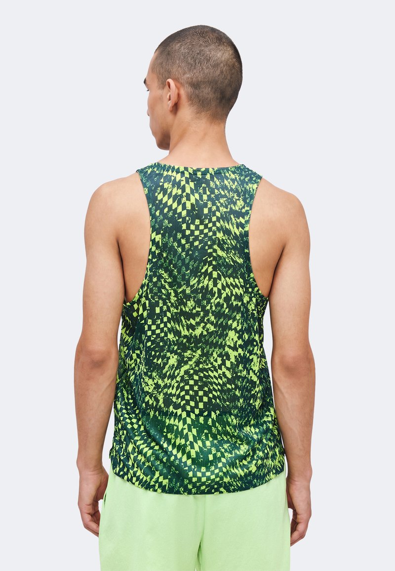 Homme portant un débardeur sans manches avec un motif de damier vert et noir déformé, vu de dos.