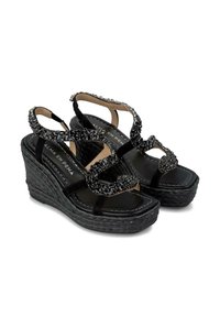 Sandali con tacco a cuneo neri realizzati in suede e materiale intrecciato, caratterizzati da perline decorative, design a strappi e suola texturizzata.