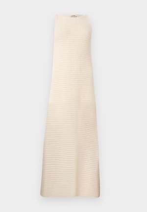 Vestido maxi sin mangas de color crema con un patrón de tejido texturizado y escote redondo, mostrado sobre un fondo gris claro liso.