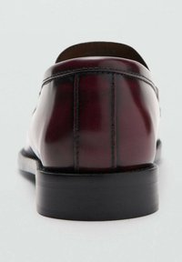 Skórzane mokasyny w głębokim bordowym kolorze z połyskiem, wyposażone w zaokrąglony nosek, subtelne przeszycia oraz niską czarną gumową podeszwę.