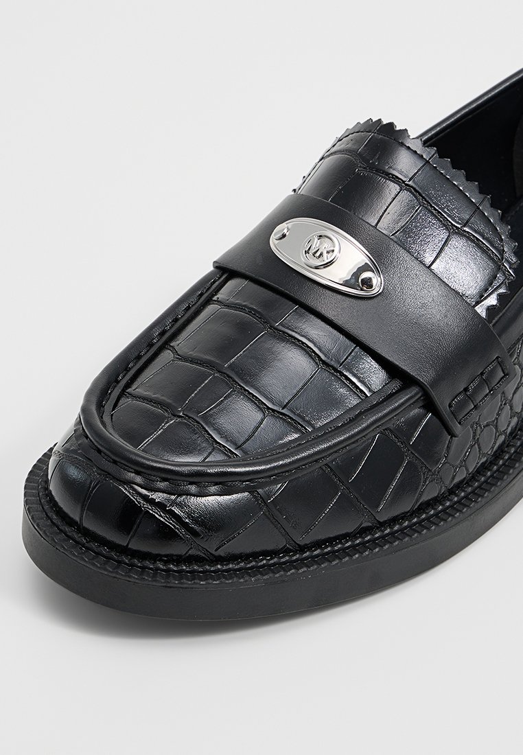 Schwarze Lederloafer mit einer strukturierten, krokodilgemusterten Oberfläche. Verfügt über eine silberne Logo-Plakette und eine genähte, abgerundete Sohle für zusätzliche Details.