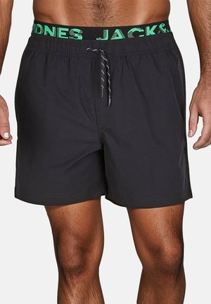 Shorts de bain noirs avec une ceinture élastique verte portant le texte "JONES JACK &". Le design inclut un cordon de serrage et une texture lisse.
