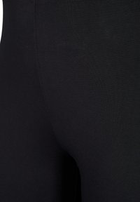 Black leggings made of stretchy fabric, featuring a smooth texture and a fitted shape. No visible patterns or hardware details.