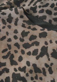 Kangas beige dengan pola cetakan leopard hitam; permukaan mesh bermaterial tekstur; dilengkapi trim hitam di sepanjang tepinya.