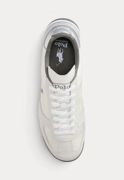 Białe trampki Polo Ralph Lauren z białymi sznurowadłami, szarym kołnierzem i czarną wkładką z logo Polo i grafiką jeźdźca na koniu.