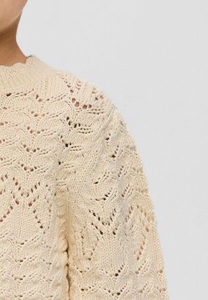 Gestrickter Pullover in hellbeige mit einem strukturierten Muster, das wellenartige Designs zeigt, und einem Rundhalsausschnitt. Gerippte Abschlüsse an den Ärmelbündchen.