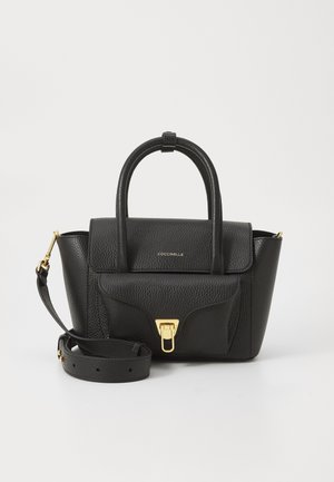 Sac à main en cuir noir avec une finition texturée, deux poignées supérieures, une bandoulière amovible, quincaillerie dorée, et un rabat avec une fermeture à clasp.