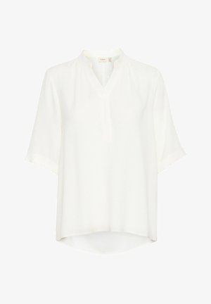 Blouse blanche à manches courtes avec un col en V, présentant une coupe ample et un tissu texturé. L'ourlet est légèrement plus long à l'arrière.