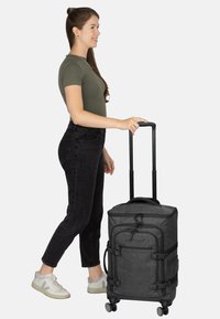 Rollkoffer aus dunkelgrauem Stoff, rechteckige Form, mit mehreren Taschen, verstellbaren Gurten und einem teleskopierbaren Griff auf Rollen.