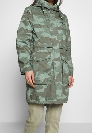 Groene camouflage parka met capuchon, trekkoorden en twee grote vo vakken; gemaakt van lichtgewicht stof met een waterbestendige textuur.