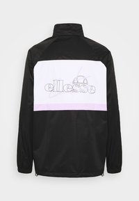 Schwarze Jacke mit hohem Kragen, ausgestattet mit einem weißen Einsatz und lila Streifen über den Rücken sowie einem umrandeten Logo. Hergestellt aus glattem, leichtem Material.