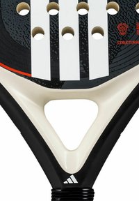 Racchetta da paddle Adidas con una superficie da colpo a strisce bianche e nere, multiple aperture e un'impugnatura testurizzata con un design a gola triangolare.