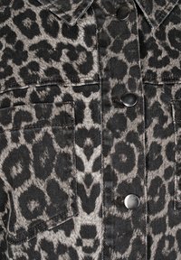 Leopardprint-Jacke mit einem grauen und schwarzen Design, Denim-Material, Knopfverschluss und Brusttaschen mit Nähdetails.