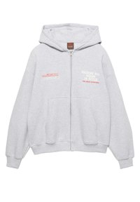 Šedá mikina na zip vyrobená z měkké tkaniny. Má kapuci, přední kapsy a potisk v červené a bílé barvě. Volnější střih s žebrovanými manžetami.