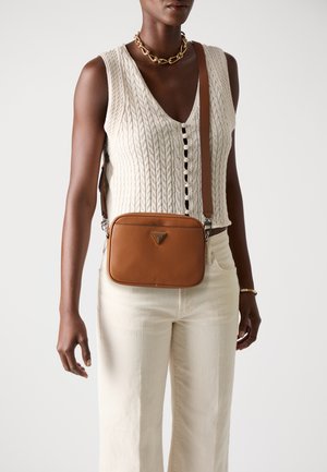 Sac en cuir brun en bandoulière avec une finition texturée ; forme rectangulaire, quincaillerie en métal argenté et accent logo à l'avant.