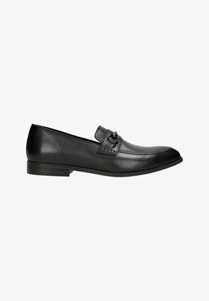 Schwarze Lederloafers mit glatter Textur, abgerundetem Zeh und minimaler Naht. Der Schuh verfügt über einen dekorativen Riemen mit einem metallischen Akzent.