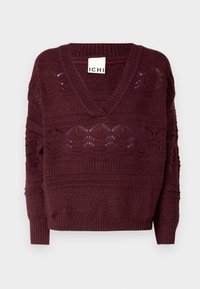 Vinröd stickad tröja med V-ringning, med texturerade mönster och ribbade muddar. Lätt texturerad med öppna vävda sektioner för ventilation.