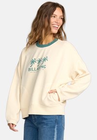 Cremefarbener Pullover mit grünem Besatz und Palmbaum-Graphic. Er hat eine lässige Passform und eine Fronttasche und besteht aus weichem Stoff.