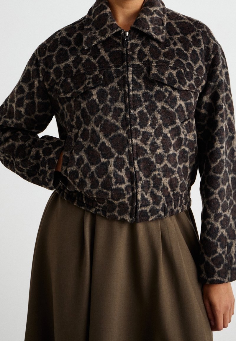 Jaguarprickig jacka med fuskpälsstruktur, dragkedjestängning och två framfickor. Kort design med krage. Bruna och beige toner.