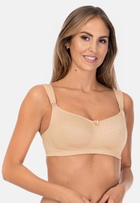 Beżowy biustonosz wykonany z miękkiej tkaniny, z szerokimi regulowanymi ramiączkami, gładkimi miseczkami oraz ozdobną kokardką na środku z przodu.