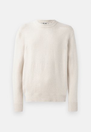 Svijetlosmeđi pulover s okruglim izrezom i rebrastim manžetama. Mekani teksturirani materijal s dugim rukavima i ravnim rubom. Minimalistički dizajn.