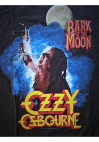 Vlkodlak vyjí bankou pod úplňkem, obklopen modrou mlhou, s červeným a žlutým textem "Ozzy Osbourne" a "Bark at the Moon".
