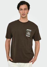 Brun bomulds t-shirt med grafisk tryk, der har "ASCENT" og "PEAKS" samt et bjergdesign og pile, korte ærmer og rund hals.