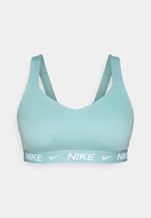 Sujeción deportiva Nike en azul claro, con un diseño sin costuras, tirantes ajustables y una banda con logotipo blanco en la parte inferior. Material suave y elástico.