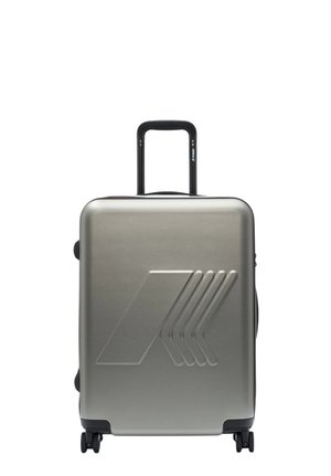 Valigia rigida argento con design a freccia in rilievo, manico telescopico esteso e quattro ruote girevoli su sfondo bianco.