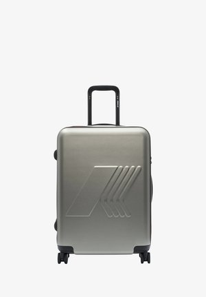 Valigia rigida argento con design a freccia in rilievo, manico telescopico esteso e quattro ruote girevoli su sfondo bianco.