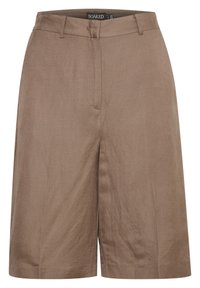 Pantaloni corti marroni a vita alta, lunghezza al ginocchio, con passanti per cintura, chiusura frontale nascosta e etichetta del brand Soaked visibile all'interno del girovita.