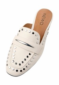 Pantofole bianche in pelle liscia, con borchie argentate e un accento metallico sulla parte anteriore. Punta rotonda e suola piatta.