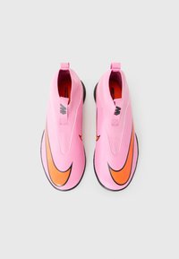 Pair of pink slip-on sports shoes with large orange Nike swoosh logos and black soles on a white background.