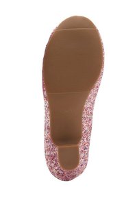 Suela de zapato rosa brillante con una superficie texturizada, que presenta una base de goma marrón suave y detalles con patrones alrededor de los bordes.