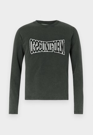 Tummanharmaa pitkähihaisen paidan, jossa on kaareva valkoinen ja musta teksti "UNIFORM" rinnan kohdalla, valkoista taustaa vasten.