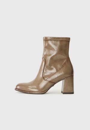 Bottines en cuir marron avec une finition brillante, un bout rond et un talon carré épais ; elles présentent un design lisse et sans couture avec des détails de couture.