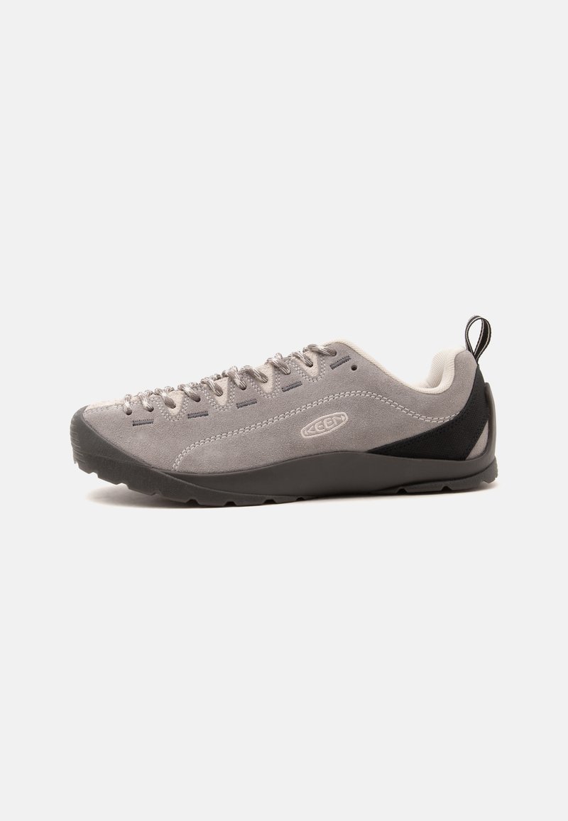 Baskets en daim gris à coupe basse avec semelle noire, patch noir au talon, plusieurs œillets avec lacets assortis et un languette arrière.